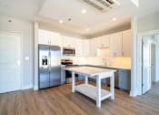 Thumbnail 3 of 8 - a large kitchen with stainless steel appliances and white cabinets
