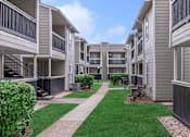 Thumbnail 6 of 35 - Building exterior walk path at Royal Wildewood Manor Apartments, Texas, 77531
