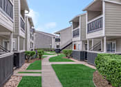 Thumbnail 8 of 35 - Walk path at Royal Wildewood Manor Apartments, Clute, TX, 77531