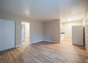 Thumbnail 3 of 20 - A room with wooden flooring and white walls.