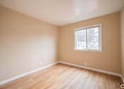 Thumbnail 6 of 20 - A room with a window and wooden flooring.