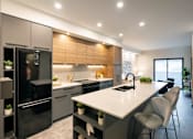 Thumbnail 13 of 22 - A modern kitchen with a large island and stainless steel appliances.