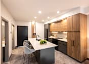 Thumbnail 14 of 22 - A modern kitchen with a dining table and chairs.