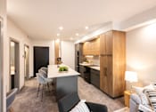 Thumbnail 16 of 22 - A modern kitchen with a dining table and chairs.