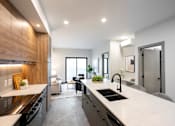Thumbnail 19 of 22 - A modern kitchen with a large island and a dining area.
