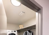 Thumbnail 11 of 22 - A laundry room with a washer and dryer stacked on top of each other.