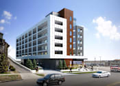 Thumbnail 8 of 22 - A modern multi-story building with a parking lot in front.