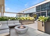 Thumbnail 22 of 35 - A patio with a fire pit and seating area.