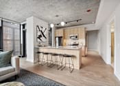 Thumbnail 4 of 35 - A modern kitchen with a bar stool and a chair.