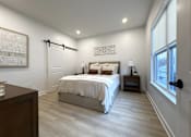 Thumbnail 6 of 22 - Typical primary bedroom with sliding barn door to en-suite bathroom & walk-in closet