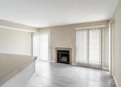 Thumbnail 1 of 20 - View of great room from kitchen area showing fireplace, faux-wood flooring, and slider to patio