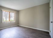 Thumbnail 9 of 20 - View of typical primary bedroom with large windows and faux plank flooring