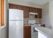 Thumbnail 3 of 20 - View of kitchen showing electric stove, refrigerator, and wood cabinetry