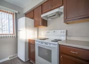 Thumbnail 5 of 20 - View of kitchen showing electric stove, refrigerator, and wood cabinetry