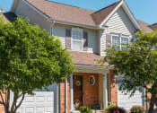 Thumbnail 15 of 27 - Exterior view of 2-story townhome & ranch end unit showing attached 1-car garage.