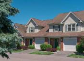 Thumbnail 19 of 27 - Exterior view of 2-story townhomes with private covered entrances & attached 1-car garages