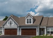 Thumbnail 21 of 22 - Exterior of Champion Reserve Townhomes showing blue townhomes with attached 2-car garages.