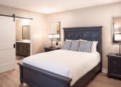 Thumbnail 10 of 22 - Interior of Champion Reserve Townhome primary bedroom with ensuite bathroom and faux wood flooring.