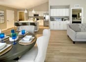 Thumbnail 8 of 22 - Interior of Champion Reserve Townhomes showing view from far side of dining area towards kitchen and coffee bar and cathedral ceiling.