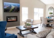Thumbnail 19 of 22 - Interior of Champion Reserve Townhomes great room with cathedral ceiling, fireplace, and faux wood flooring.