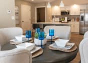 Thumbnail 9 of 22 - Interior of Champion Reserve Townhomes dining area with kitchen and breakfast bar in the background.