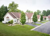 Thumbnail 23 of 31 - a neighborhood of white houses on a street with green grass and trees