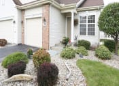 Thumbnail 28 of 31 - a front yard with rocks and plants in front of a house