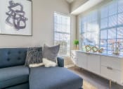 Thumbnail 4 of 31 - a living room with a blue couch and two windows