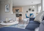 Thumbnail 7 of 31 - a living room with a couch and a table and a kitchen