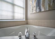 Thumbnail 19 of 31 - a bathroom with a bath tub and two windows