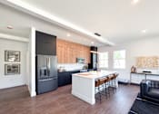 Thumbnail 5 of 29 - A modern kitchen with a refrigerator, stove, and island.