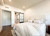 Thumbnail 9 of 29 - A bedroom with a large bed and a sliding glass door.