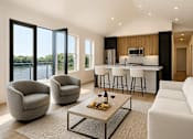 Thumbnail 23 of 29 - Artist rendering of Westport Crossing apartment living area and kitchen with breakfast bar with views of the Erie canal