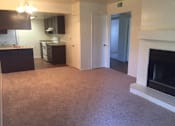 Thumbnail 7 of 8 - an empty living room with a fireplace and a kitchen