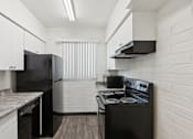 Thumbnail 30 of 42 - A kitchen with black appliances and white cabinets.