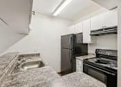 Thumbnail 31 of 42 - A kitchen with a granite countertop and stainless steel appliances.