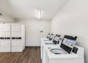 Thumbnail 41 of 42 - A row of washing machines are lined up in a laundromat.