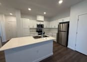 Thumbnail 10 of 16 - A kitchen with white countertops and stainless steel appliances.