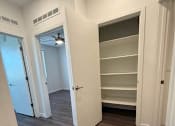Thumbnail 11 of 16 - A room with a fan and shelves in it.