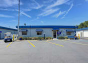 Thumbnail 10 of 29 - an empty parking lot in front of a building with a blue roof