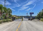 Thumbnail 15 of 29 - a highway with a bridge over a body of water with palm trees