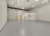Thumbnail 17 of 29 - a large empty room with white walls and a door in the middle