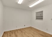Thumbnail 18 of 29 - a room with white walls and wooden floors and a window