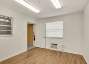 Thumbnail 24 of 29 - a living room with white walls and wood flooring and a window
