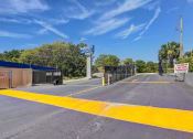 Thumbnail 25 of 29 - the entrance to a parking lot with a gate and a street sign on the side