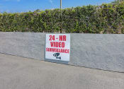 Thumbnail 27 of 29 - a video surveillance sign on a wall next to a sidewalk
