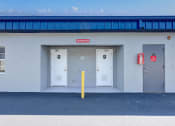 Thumbnail 29 of 29 - the outside of a building with three doors and a red fire hydrant