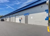 Thumbnail 9 of 29 - the side of a warehouse building with a car parked outside