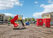 Thumbnail 36 of 60 - A playground with a red slide and a red climbing structure at Venue at 109 Apartments, Tennessee