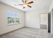 Thumbnail 5 of 60 - A room with a ceiling fan and a window overlooking a patio at Venue at 109 Apartments, Lebanon , Tennessee